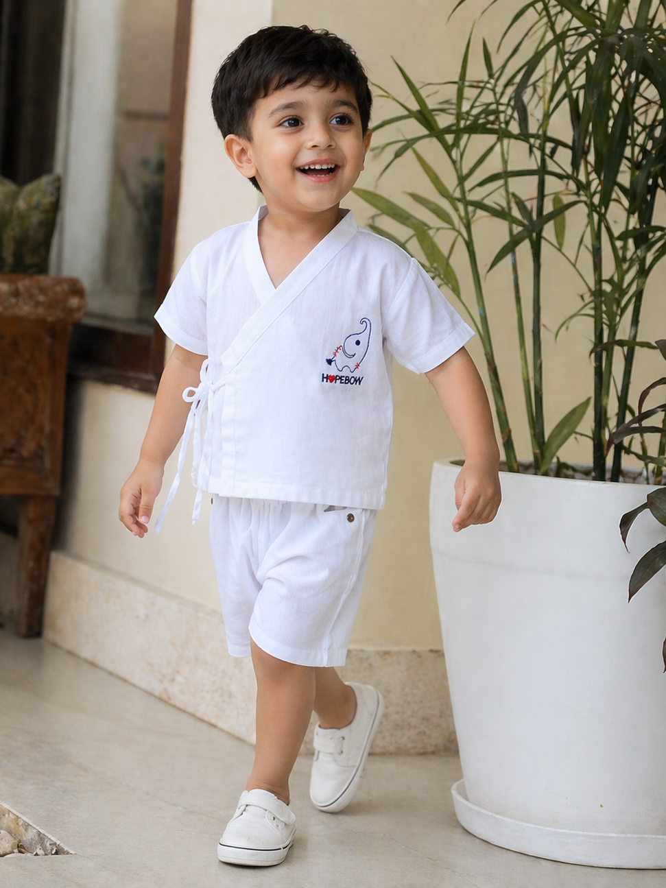 Boy wearing Hopebow heritage white shirt and shorts