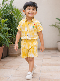 Boy wearing Hopebow yellow gingham shirt and shorts