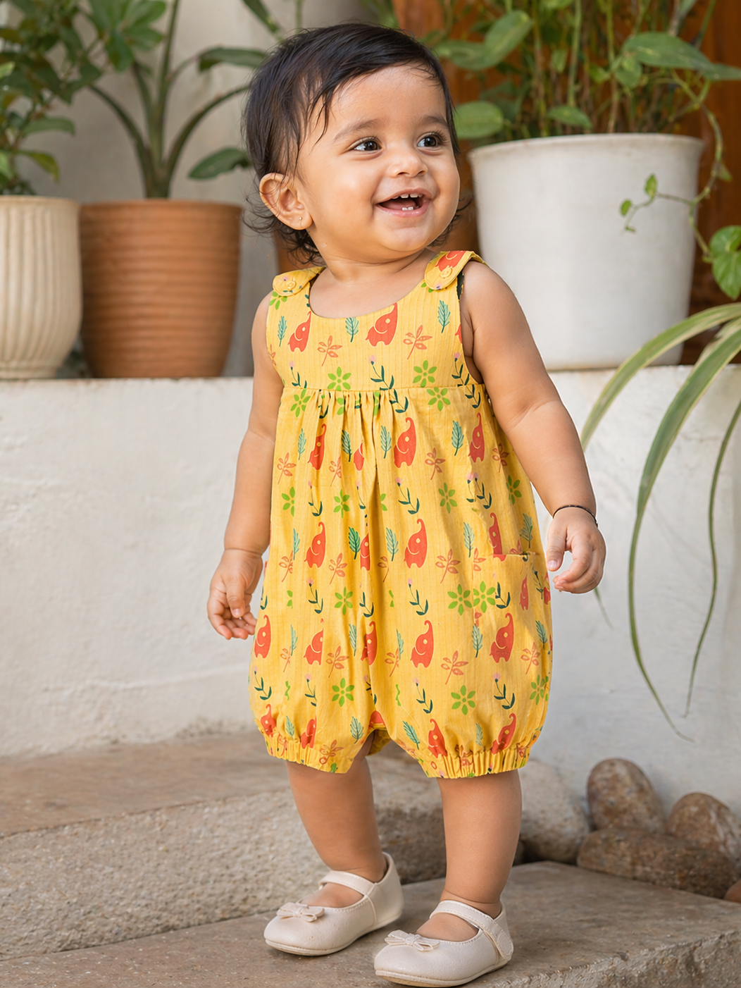 Baby girl wearing Hopebow yellow elephant print romper