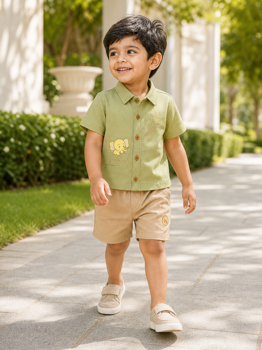 Boy wearing Hopebow sage shirt with embroidered elephant motif