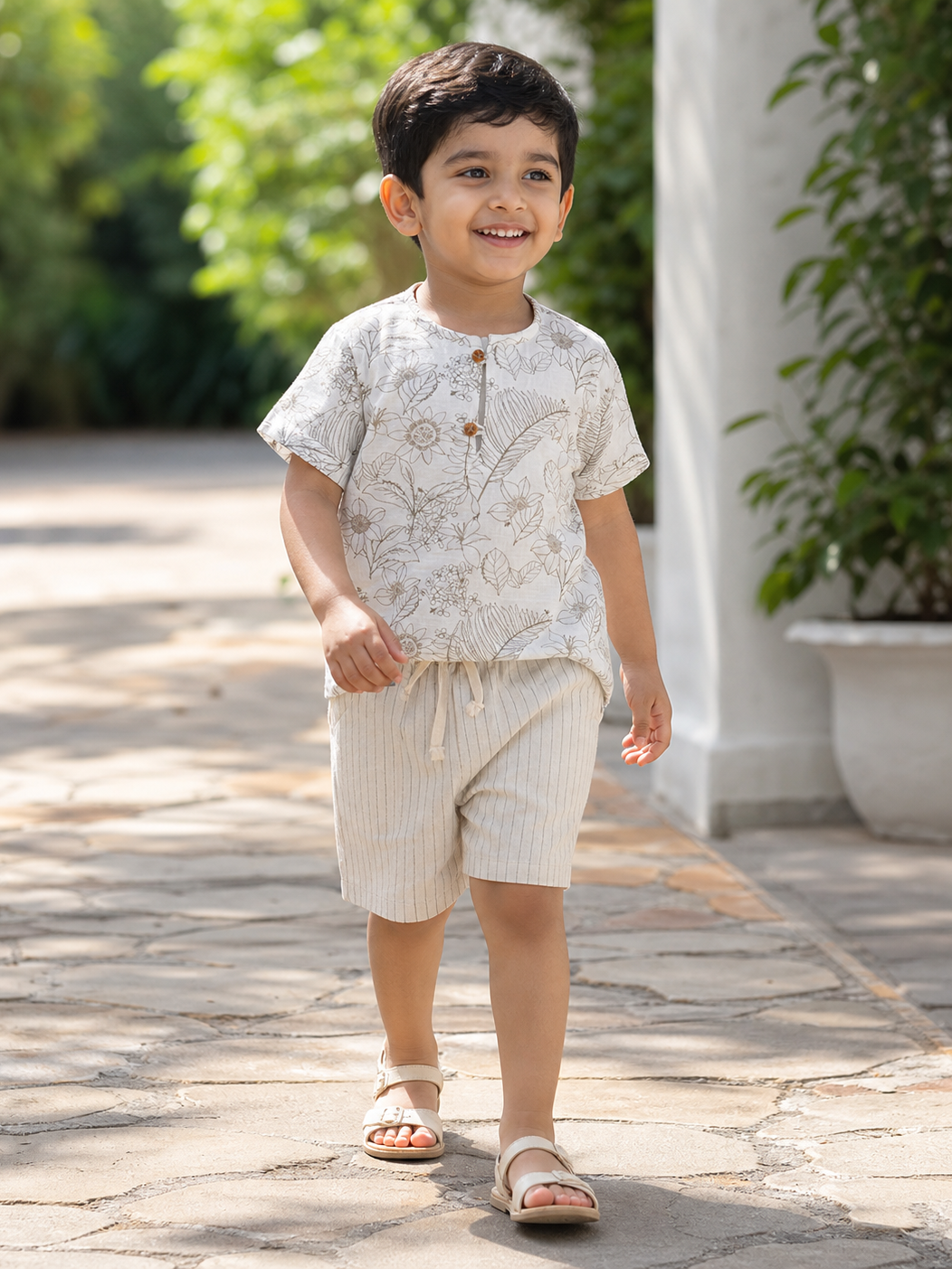 Child wearing Hopebow botanical print tee with striped beige shorts