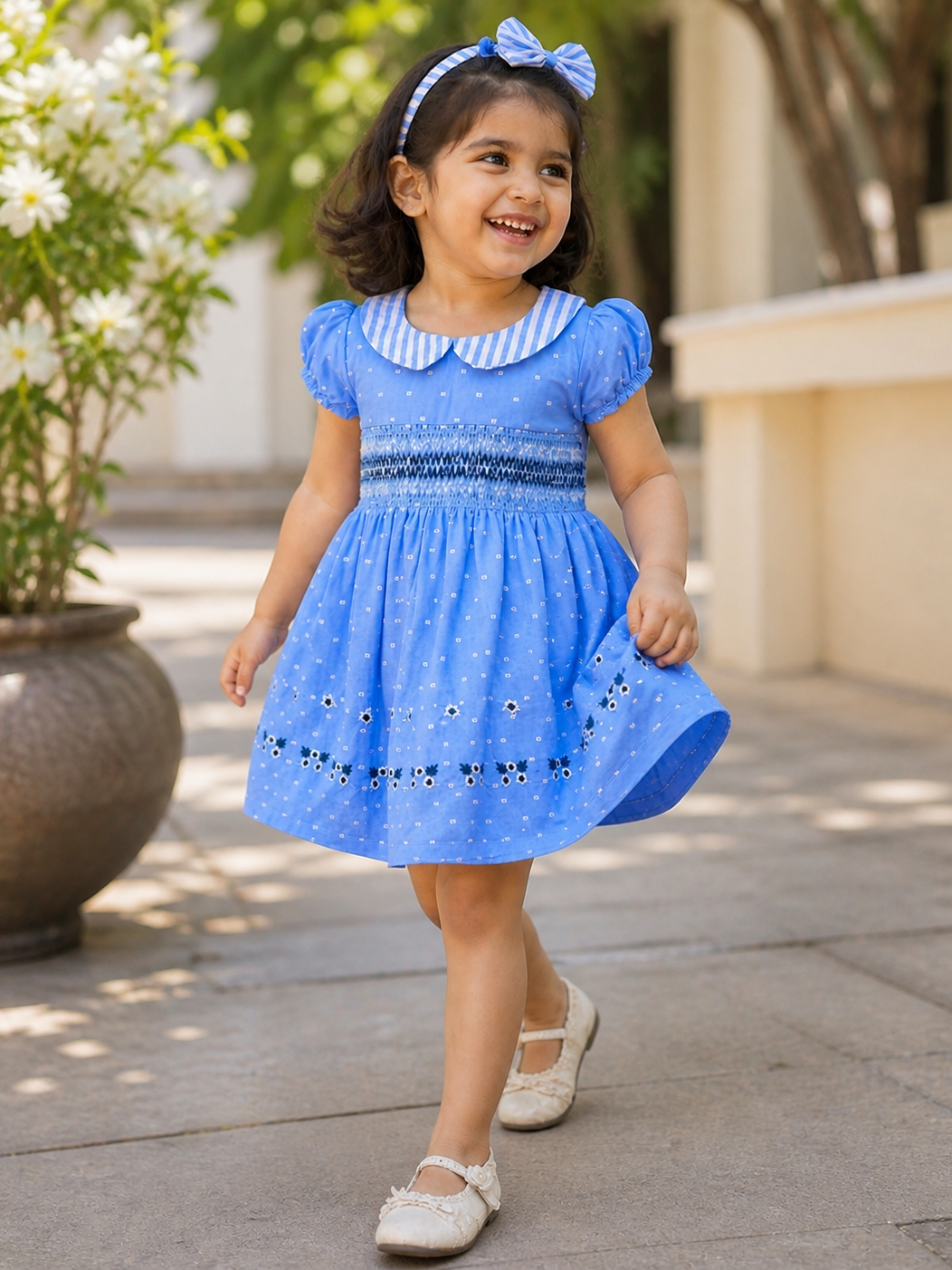 Girl wearing Hopebow Celeste blue smocked dress