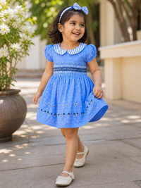 Girl wearing Hopebow Celeste blue smocked dress