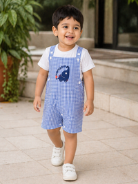 Baby boy wearing Hopebow blue gingham dungaree romper